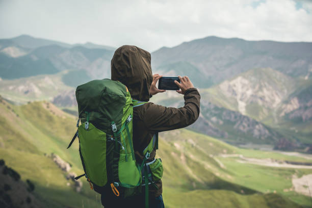 istock Hiker on high altitude mountain top using smartphone 1372685586