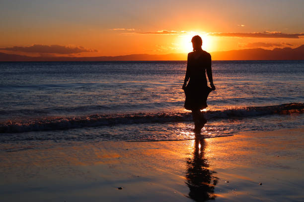 istock Beautiful young woman relaxing at sunset beach 1372687042