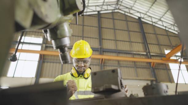istock Industrial mechanical engineer or technician or machinery operator have proficient, wear personal protective equipment, set up of steelwork machine at production line in heavy manufacturing factory. 1372690370