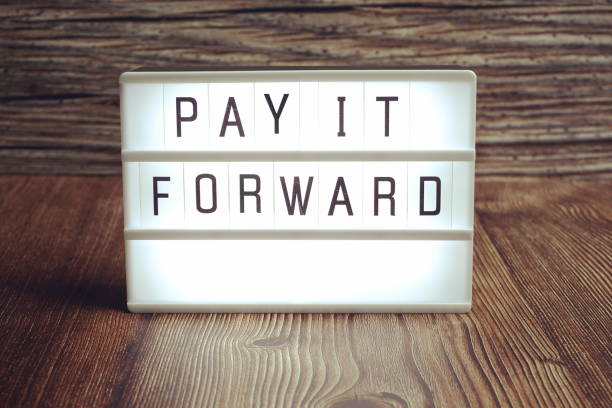 istock Pay It Forward word in light box on wooden background 1372693097