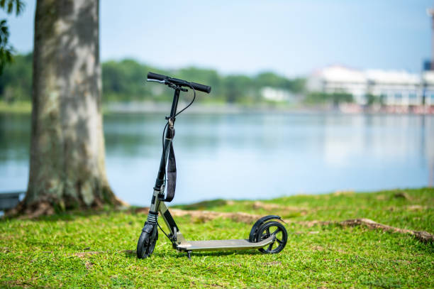 Kick scooter in the public park. Outdoor activity for children on safe residential street. Active sport for preschool kid.