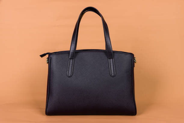 istock A black leather bag on an orange background. 1372693572