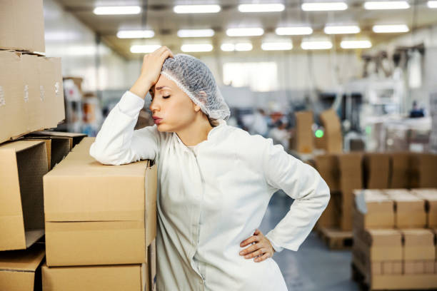 A food factory worker having troubles at work. stock photo