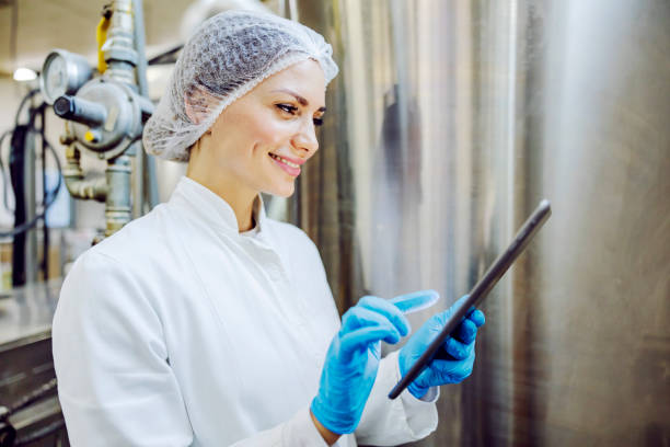 un supervisor de fábrica de diario desplazándose en la tableta. - food hygiene fotografías e imágenes de stock