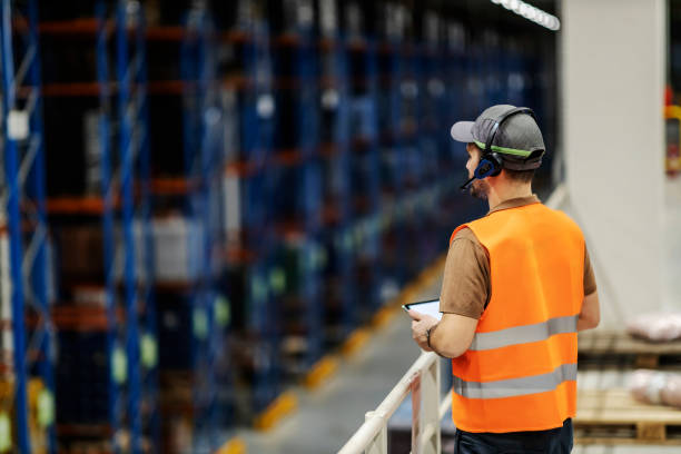 istock A boss with voice picking headset and tablet monitoring loading in storage. 1372696267