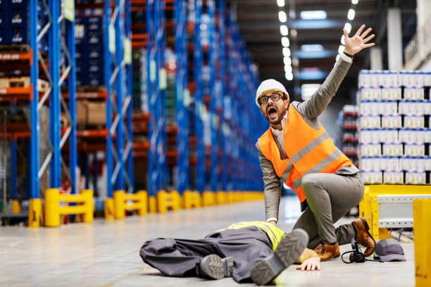 istock A scared inspector screaming for help for his injured laying worker at warehouse. 1372697238
