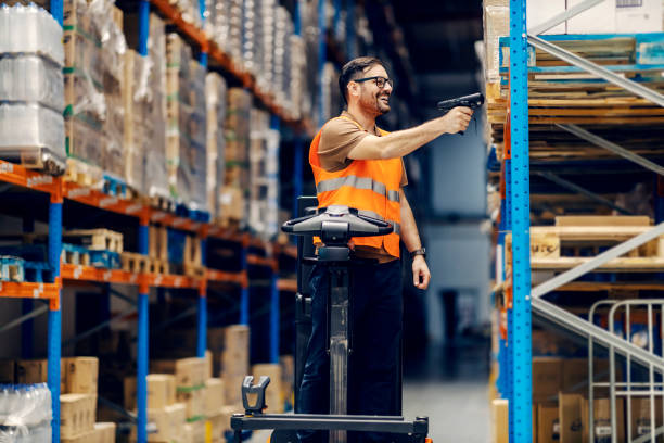 istock A smiling supervisor on forklift scanning boxes with qr and bar code scanner in warehouse. 1372697303