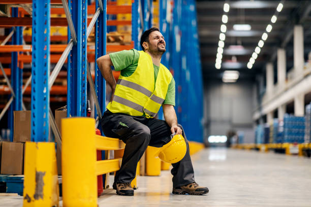 istock A warehouse worker having back pain and rubbing it. 1372698223