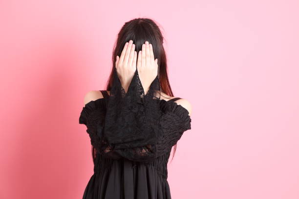 The cute young Asian girl with gothic dressed standing on the pink background