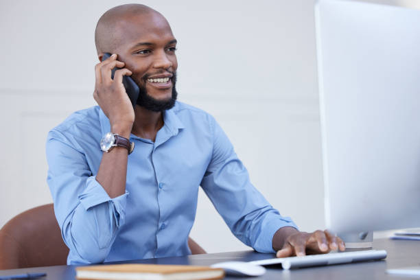 istock Shot of a young businessman using a computer while on a call at work 1372703465