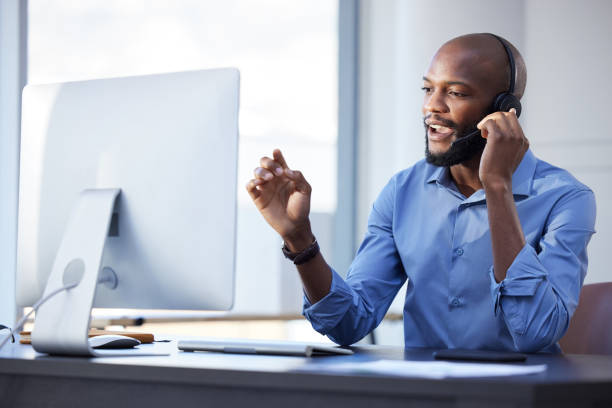 Shot of a young male call center agent working in an office I can help you with anything businessman african descent on the phone business person stock pictures, royalty-free photos & images