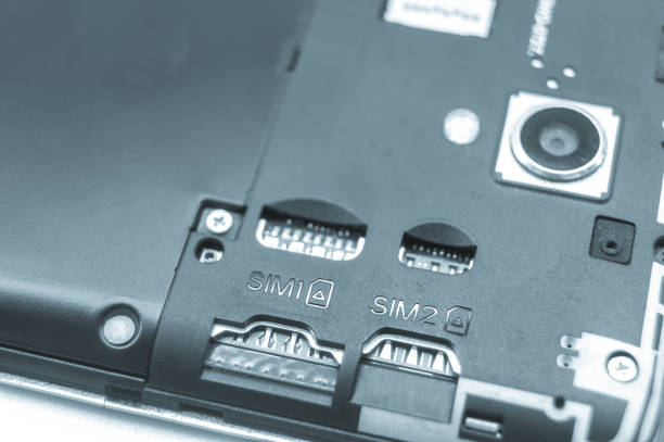 istock Slots for two SIM cards in a smartphone with an open back cover. Empty SIM slots. Blue tint. Selective focus 1372706730