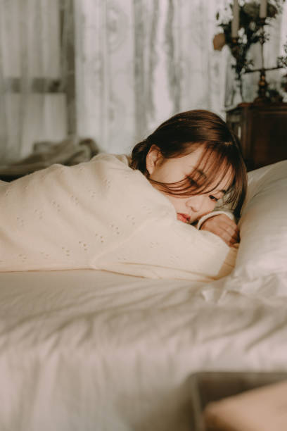istock Asian girls lying in bed 1372706754