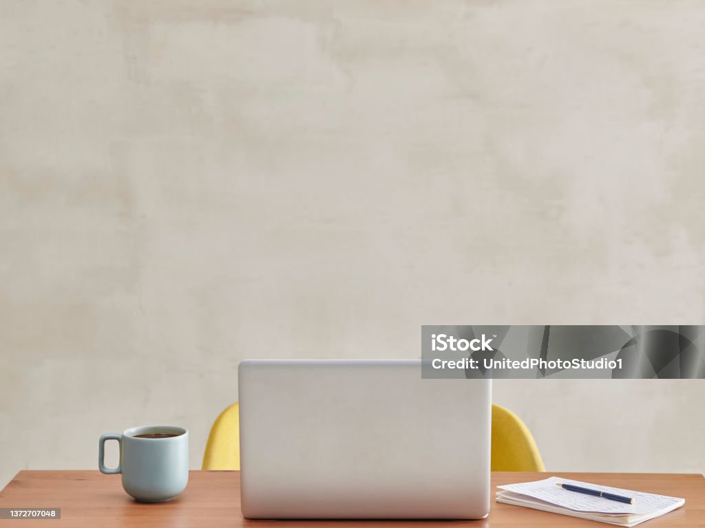 The back of laptop in the room, wooden table yellow chair coffee style. Laptop Stock Photo