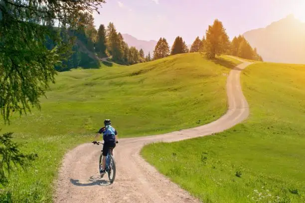 Photo of Biker riding scenic path in beautiful summer mountain scenery , Dolomites Italy, European Alps.