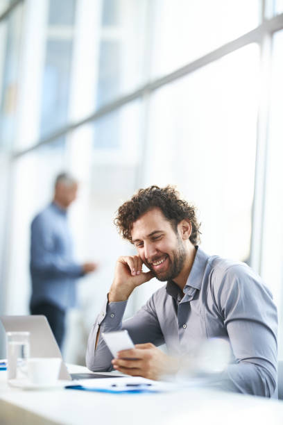 istock Happy male entrepreneur using cell phone in the office. 1372709965