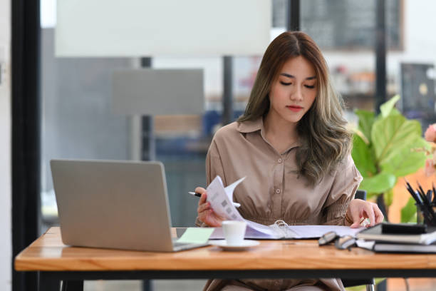 istock Concentrated young businesswoman checking financial reports and using computer laptop. 1372710022