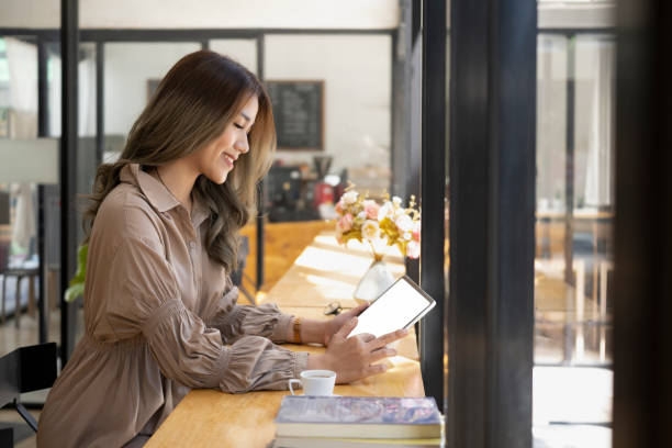 istock Side view beautiful asian woman freelancer checking email on digital tablet. 1372710936