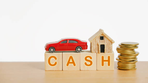 miniature house and red car on stack of coin with cash word on  wood cube and stack of coins for finance, refinance, leasing, rental concept stock photo