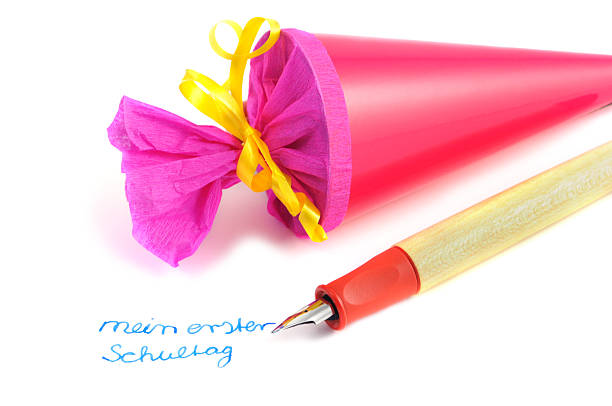 Conical bag of sweets pen with German word first schoolday Conical bag of sweets and pen with German word mein erster schultag (my first schoolday) zuckertüte stock pictures, royalty-free photos & images