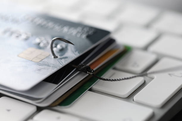 Fishing hook with credit cards on keyboard closeup stock photo
