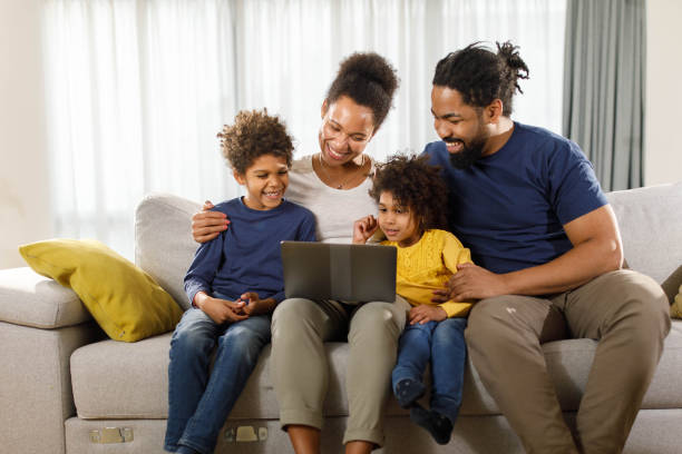 istock Happy black family using laptop on sofa at home. 1372715889