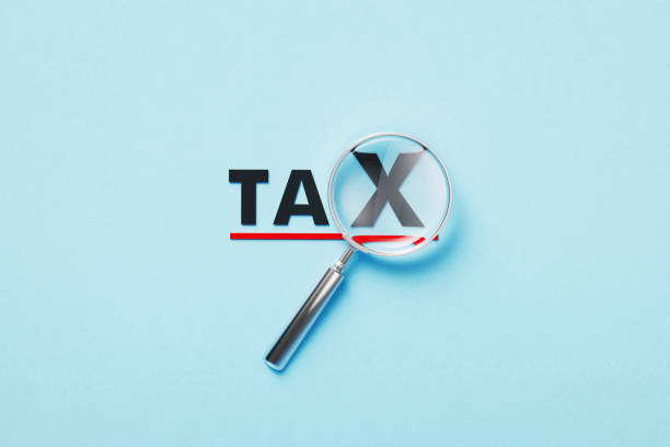 istock Magnifier Forming Tax Word On Blue Background 1372716373