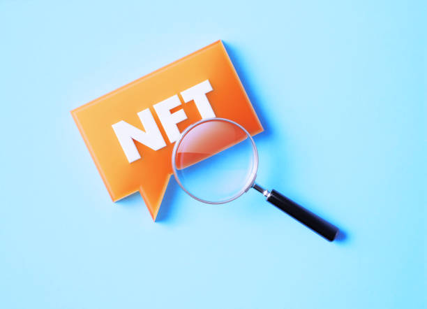 istock Magnifier And Speech Bubble With NFT Abbreviation On Blue Background 1372716773