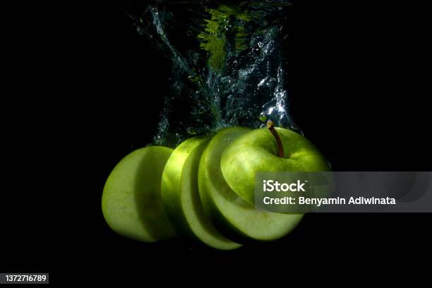 Slice Of Green Apple In The Water Stock Photo - Download Image Now - Apple - Fruit, Close-up, Color Image