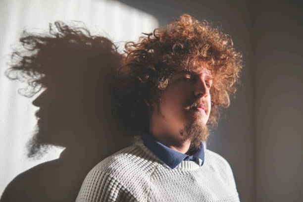 Portrait of a man with curly hair enjoying the warmth of early morning sun