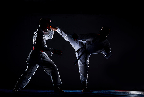 Karate men with black belt posing, champion of the world on black background studio shot