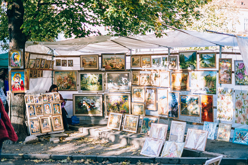 Many different paintings of unknown artist being sold at a flea market in Kyiv