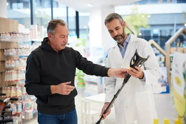 Photo of A drugstore client and a pharmacist talk in the shop.