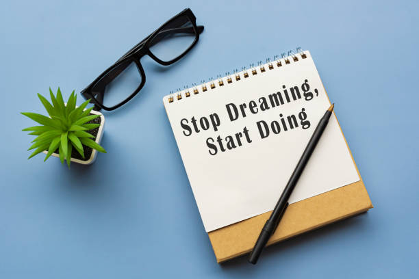 istock Motivational and inspirational quote on notepad - Stop dreaming, start doing. 1372728013