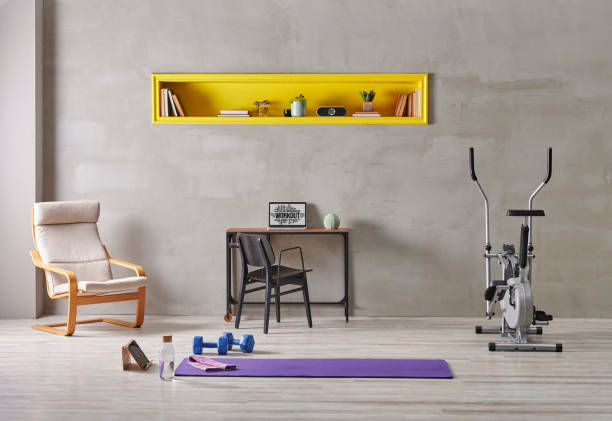 istock Sportive and training room style with purple mat dumbbell, computer background.Yellow bookshelf shelf book flower i pad laptop computer 1372729099