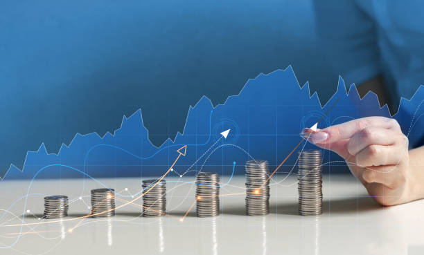 istock Hand putting money coin stack with growing business graph.Saving money concept. 1372729601