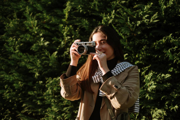 istock Young woman taking a picture with a vintage camera 1372734000