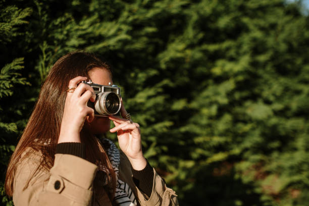 istock Young woman taking a picture with a vintage camera 1372734039
