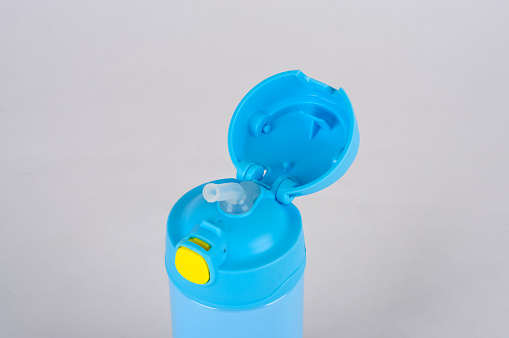 Closeup of drinking bottle on white background. There are straws.
