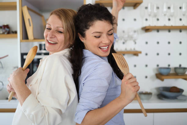istock Mother and daughter having fun together while dancing in the kitchen 1372739717