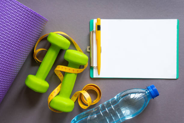 istock Green dumbbells on a dark gray paper background . 1372741843