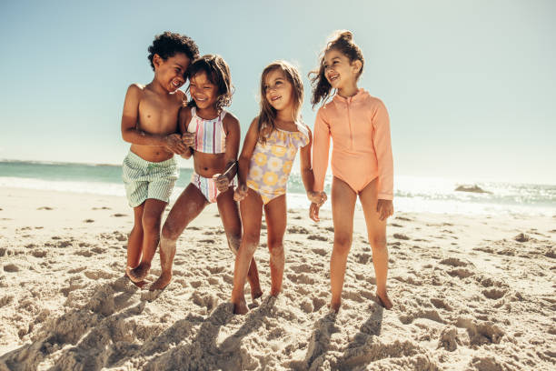 istock Cheerful kids playing together on beach sand 1372742190