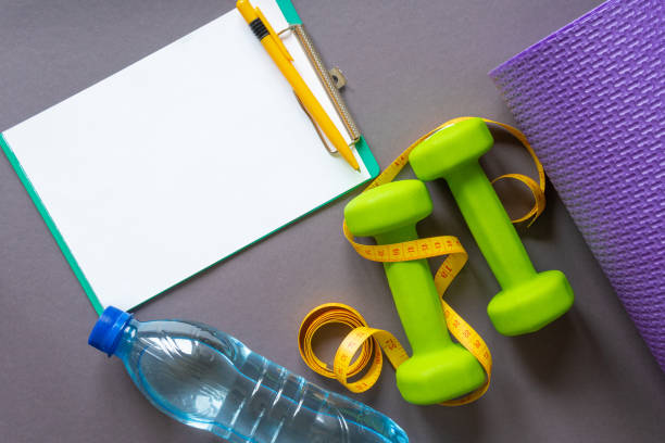 istock Green dumbbells on a dark gray paper background . 1372742445
