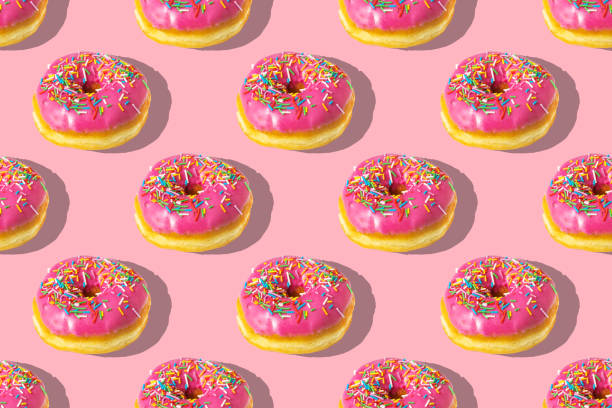 istock Repeating pattern of pink donuts on a pink background. Flat lay 1372742503