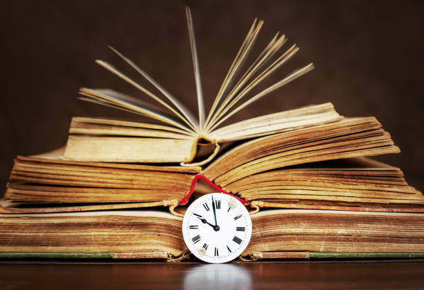 istock Old books and vintage clock face, storytelling 1372742524
