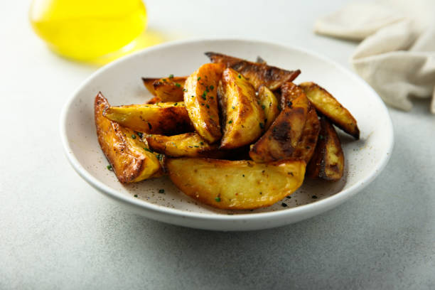 spicchi di patate arrosto - roasted potatoes prepared potato herb food foto e immagini stock