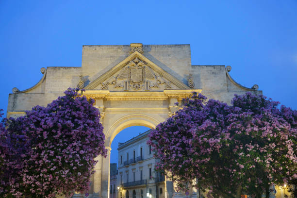 Lecce: Porta Napoli, ancient arch Lecce, Apulia, Italy: Porta Napoli, historic door with arch at evening lecce stock pictures, royalty-free photos & images