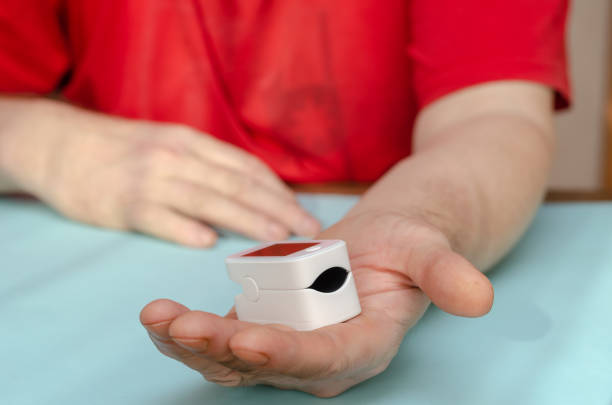 istock A mature man's open palm extends into the camera with a white pulse oximeter. 1372743724