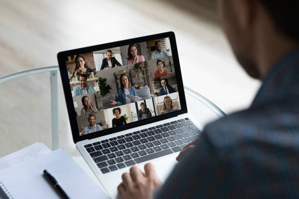 istock View over businessman shoulder group video call on laptop screen 1372744096