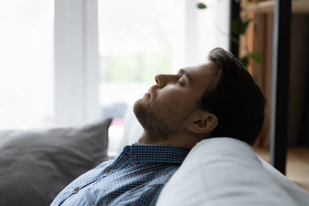 istock Close up profile calm man resting leaning back on couch 1372744114